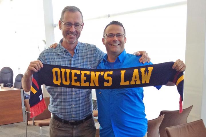 David Sharpe holds a Queen's Law scarf with Dean Flanagan