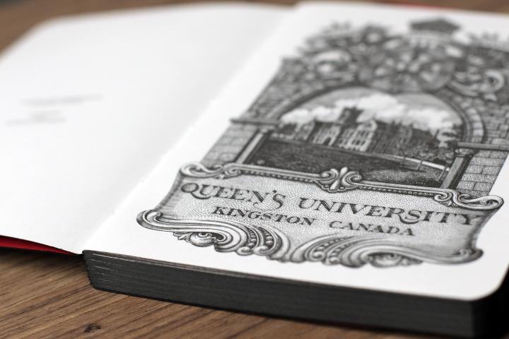Notebook opened to the first page of an illustration of the university.
