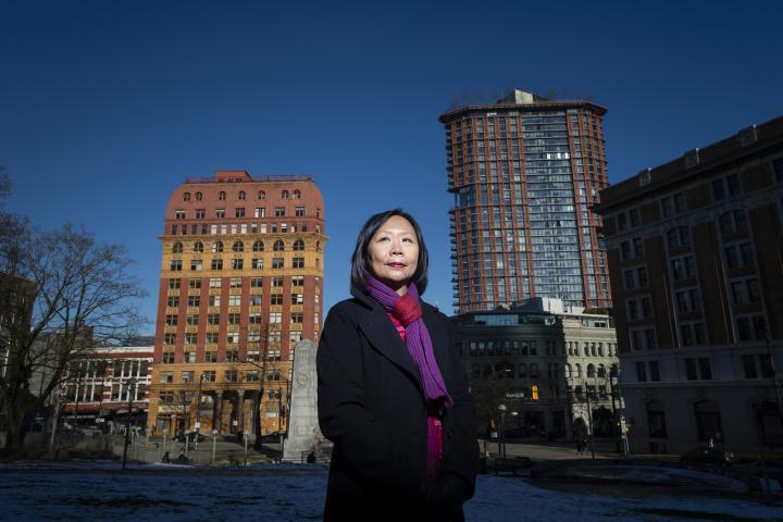 Fiona Tinwei Lam standing in from of apartment buildings in Vancouver.
