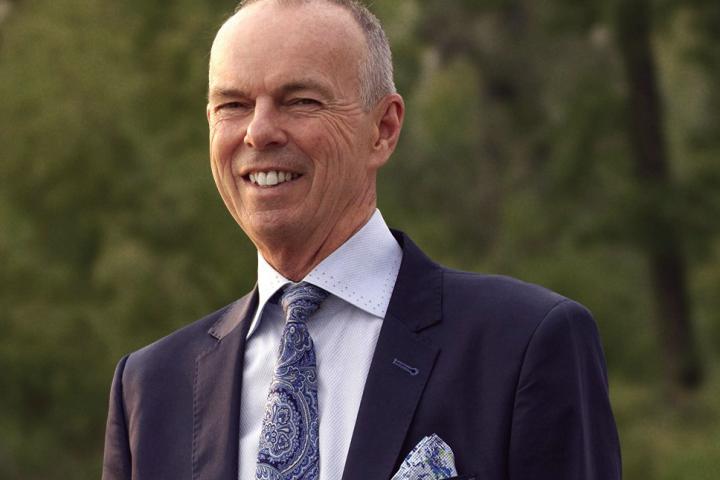 Photo of Micheal Kehler wearing a suit and smiling.