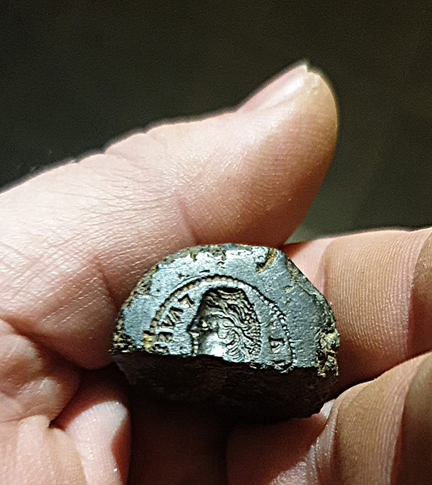 Hand holding coin fragment