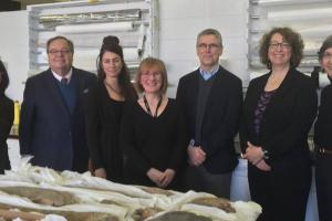 Seven people smiling in a room with art