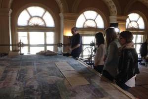 Four people looking at art on a table