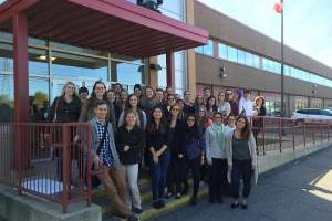 A group photo outside of a large building