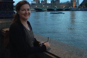 A person smiling with a city skyline in the background