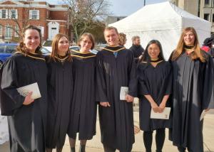 Six people smiling at a graduation ceremony