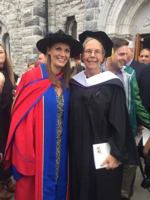 Two people smiling, one is holding a piece of paper