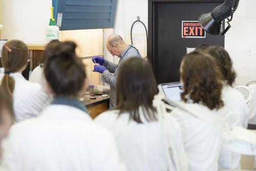People watching someone work in a lab