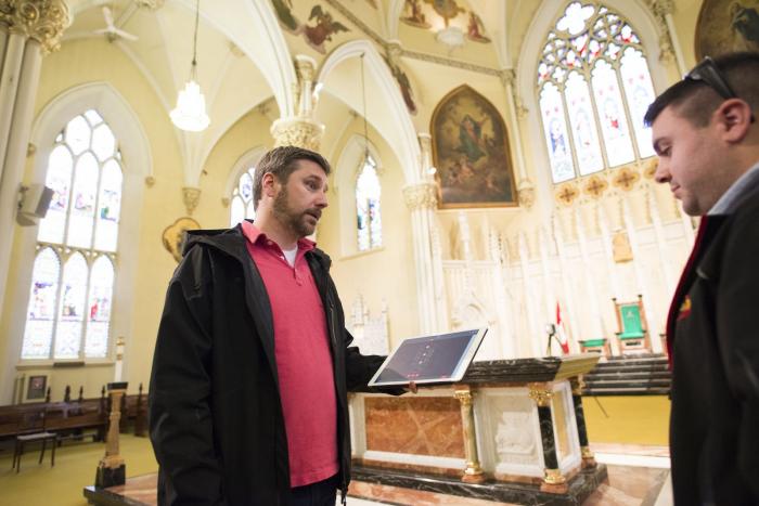 A person holding a tablet talking to other people