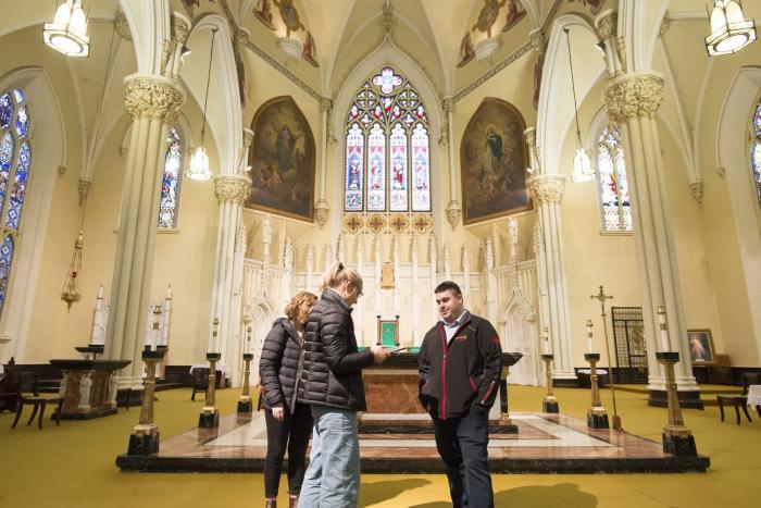 Three people working in a cathedral