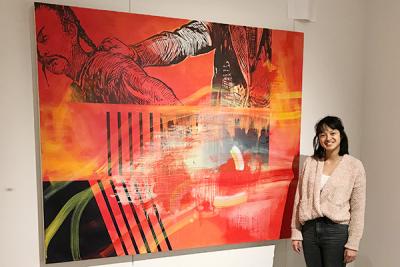 A person standing in front of a large piece of art