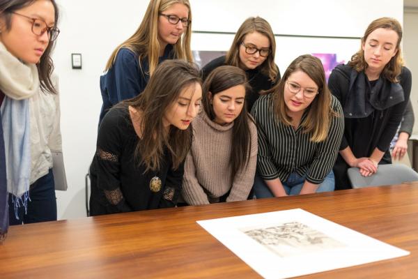 A group of people looking at a piece of art
