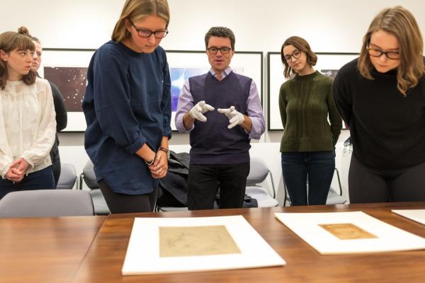 Five people gathered around a piece of art