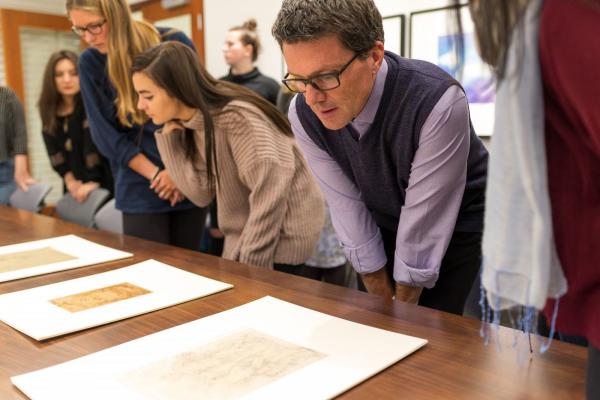 People looking at art on a table