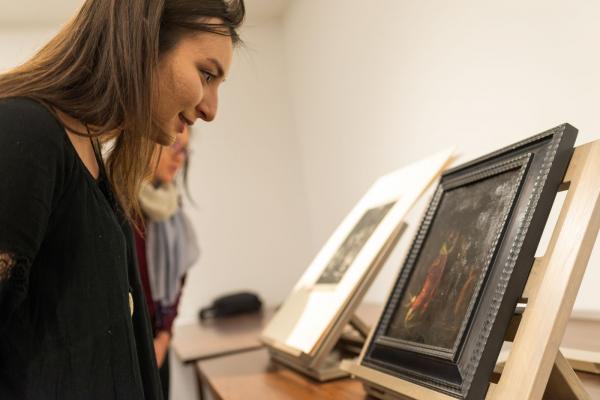 A person looking at a framed piece of art