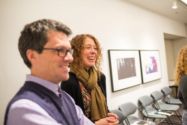 Two people smiling in a room with art on the walls