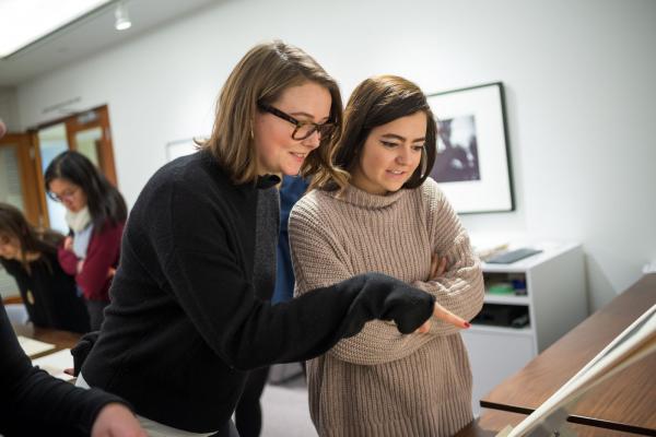Two people smiling looking at art