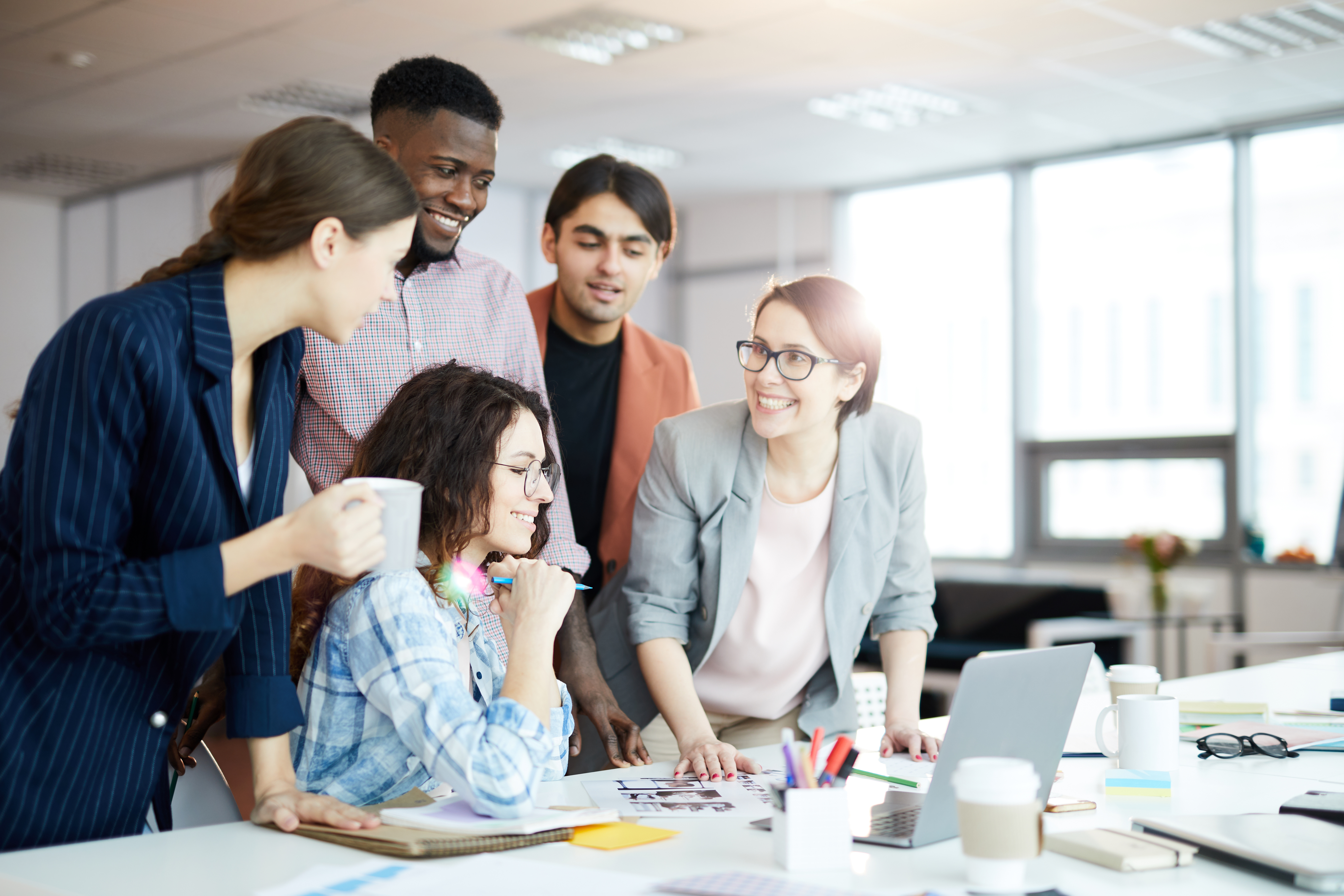 Interns standing around a desk.