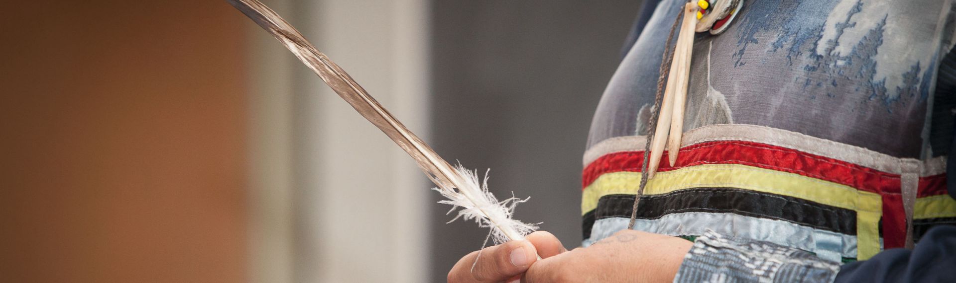 Indigenous person holding a feather 