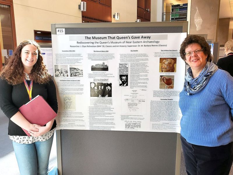 Elyse Richardson, left, a fourth-year student of classics and art history at Queen's University, and Barbara Reeves, an associate professor and an archeologist in the classics department at Queen's with a poster highlighting a former archeological