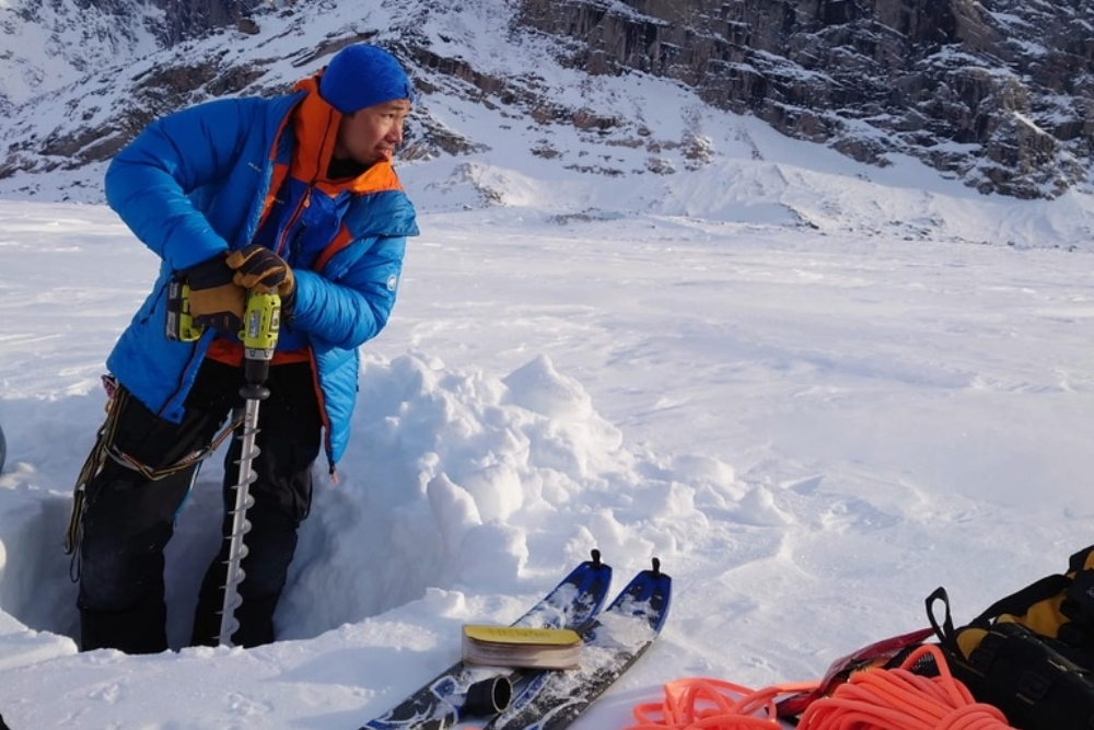 ICELab PhD Candidate Wilson Cheung drilling on Turner Glacier, Auyuittuq National Park, Baffin Island, April 2022.