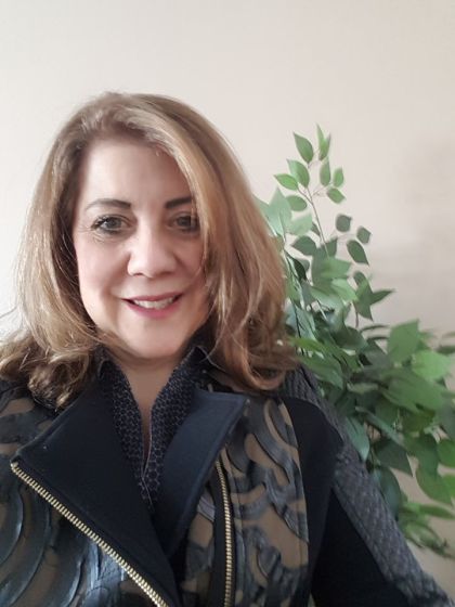 Sandra Irvine standing in front of a plant.