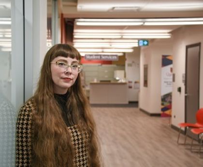 Staff member leaning against a glass wall