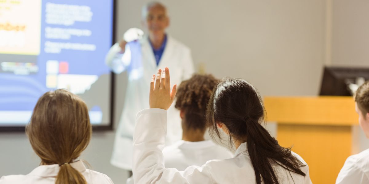 Medical student raises their hand in class