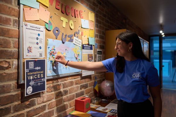 Student at QUIC posting her pin on a map.