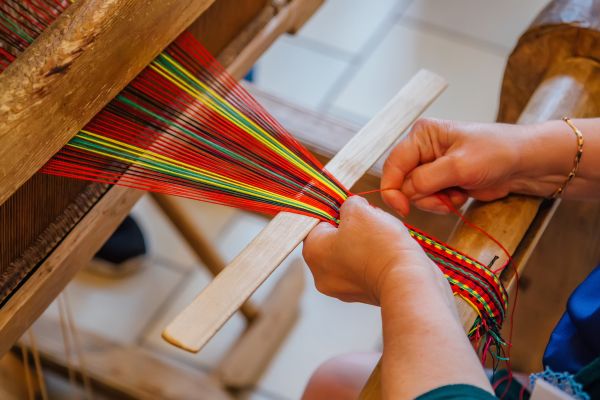 Person using a loom.