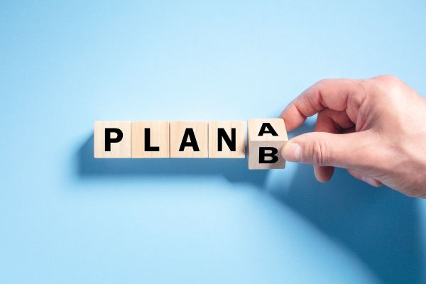 Blocks spelling out Plan A with a hand changing it to Plan B.