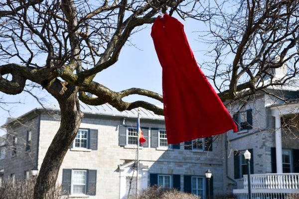 A red dress hangs from a tree at Queen's University representing Missing and Murdered Indigenous Women