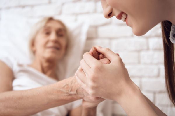 Care worker holding an elderly's hands