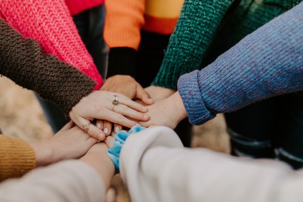community piling hands together