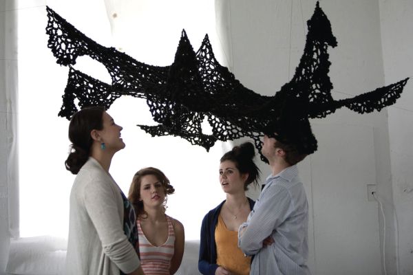 Visual Arts students with black mesh art directly above them