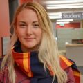 staff member leaning against a red wall