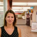Staff member leaning against a glass wall
