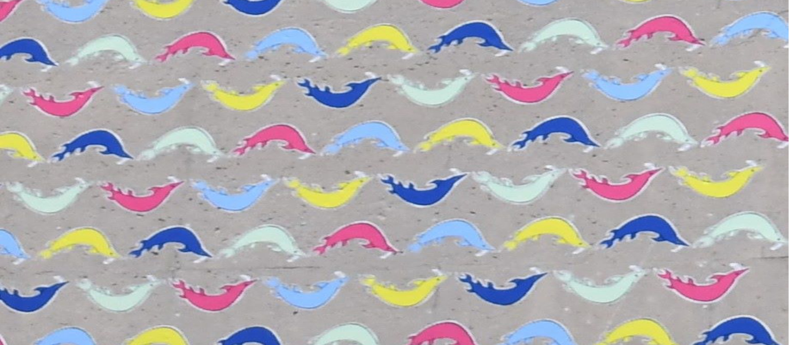 Indigenous art of different coloured whales on a wall.