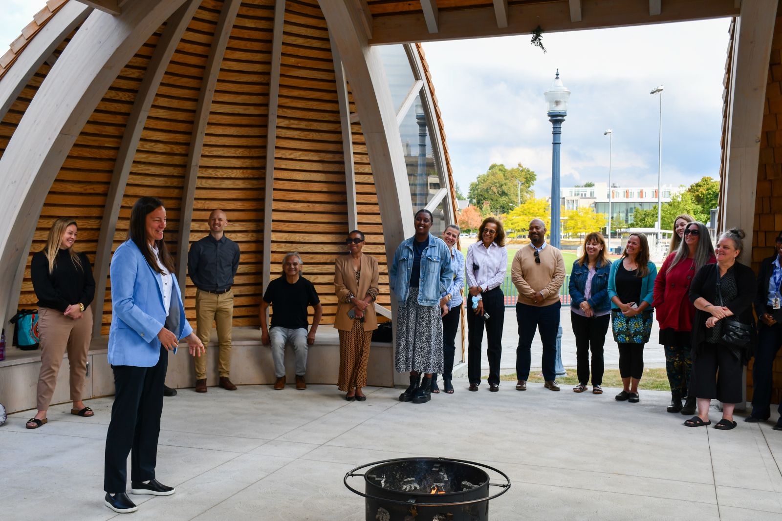 People gathered around a fire pit inside new indigenous space at Queen's University.