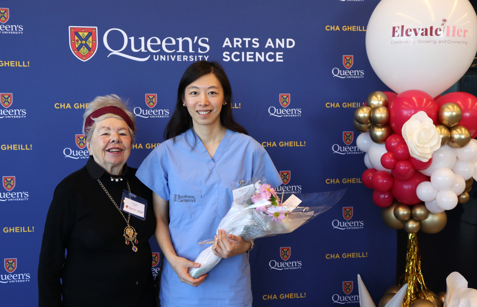 alumni at ElevateHer in front of blue Arts and Science backdrop