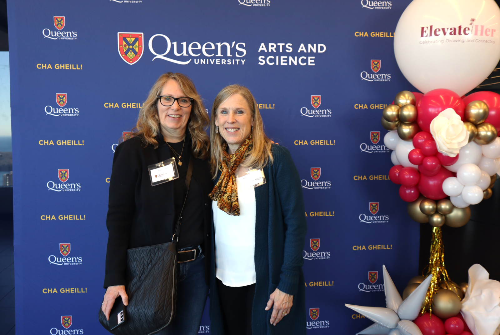 alumni posing in front of Arts and Science blue backdrop at ElevateHer