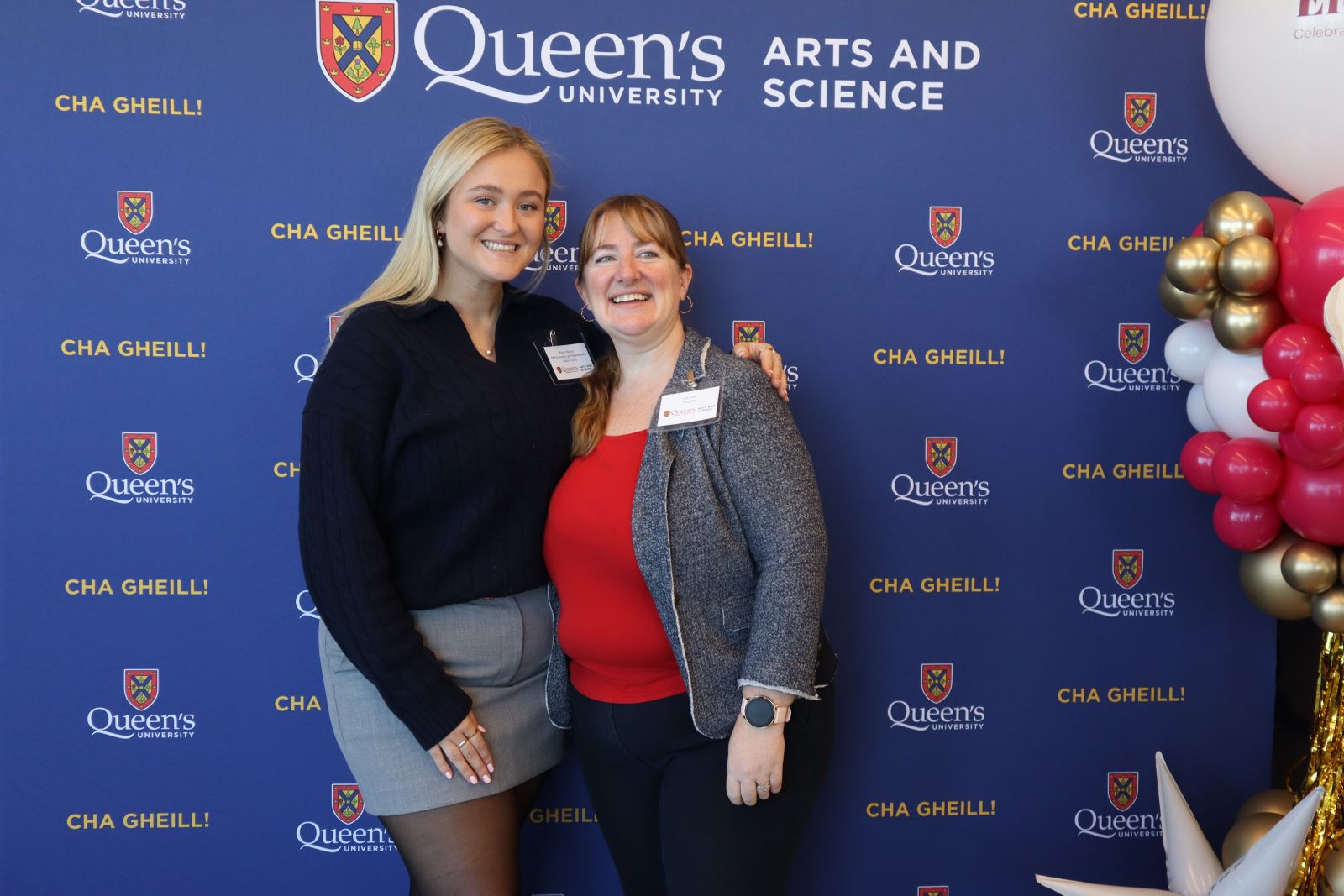alumni posing in front of Arts and Science blue backdrop at ElevateHer