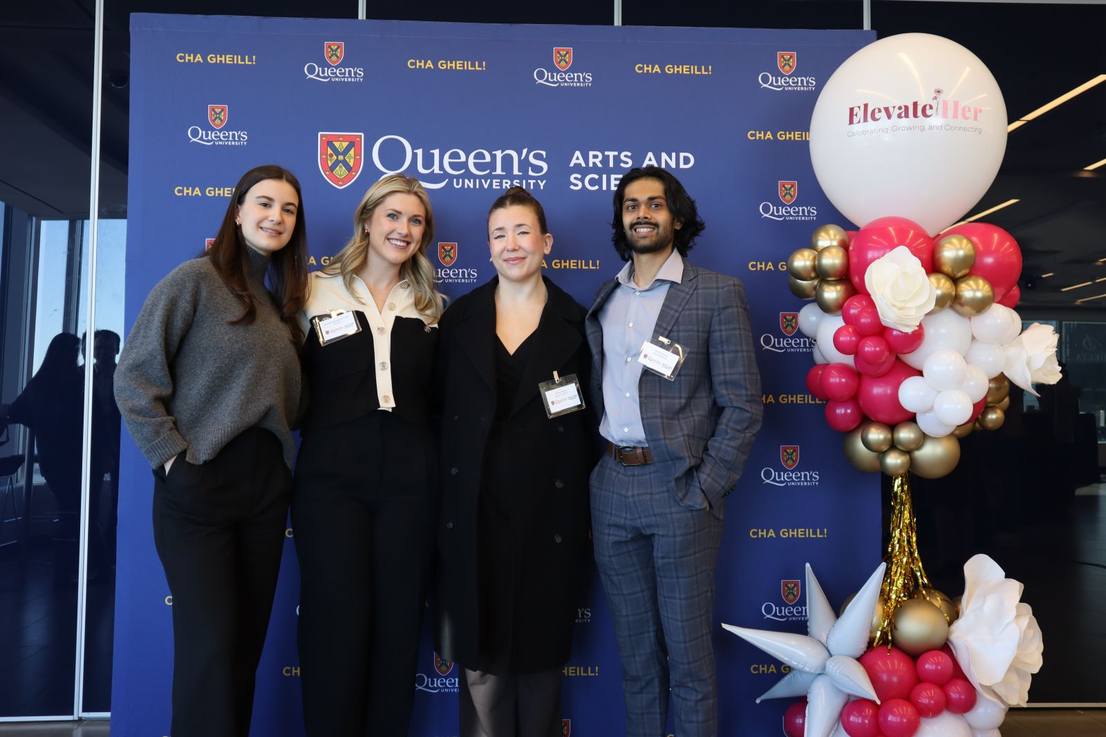 alumni posing in front of Arts and Science blue backdrop at ElevateHer