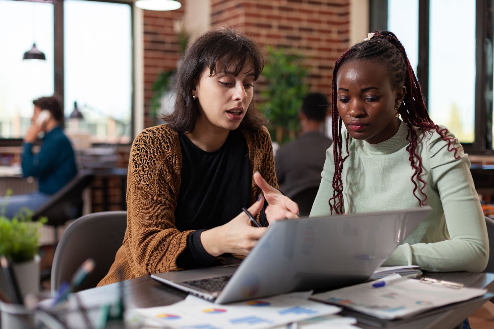 Two women looking at a laptop and conversing