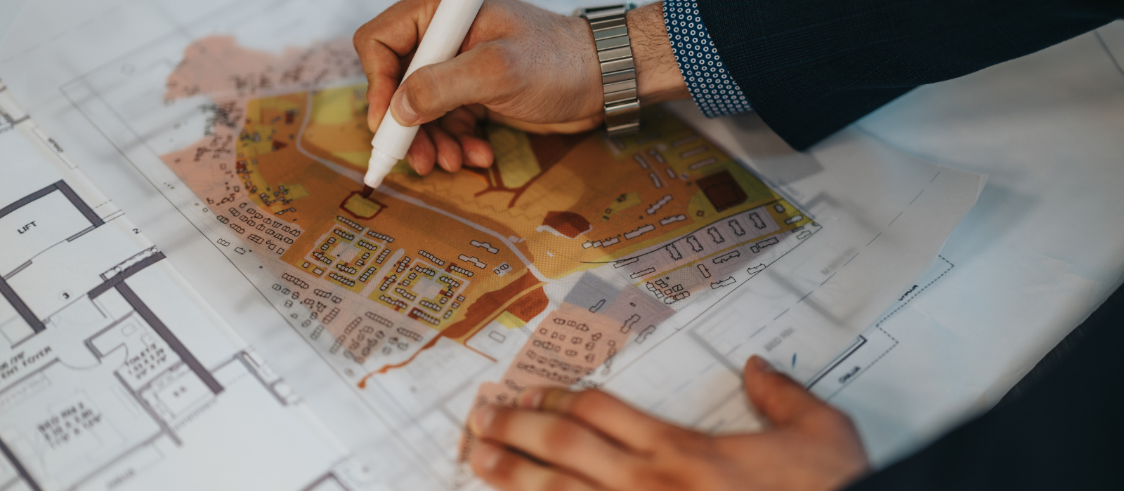 A set of hands outlining roads on a map with a marker.