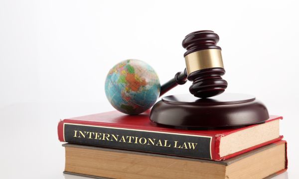 gavel and globe on a book titled International Law