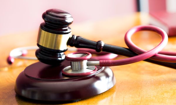 Gavel and stethoscope on wooden table