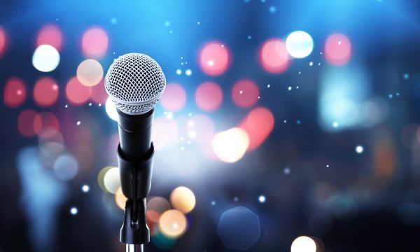 Microphone with bokeh background to represent a crowd