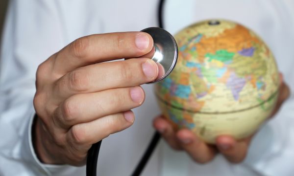 Doctor holding world globe and stethoscope