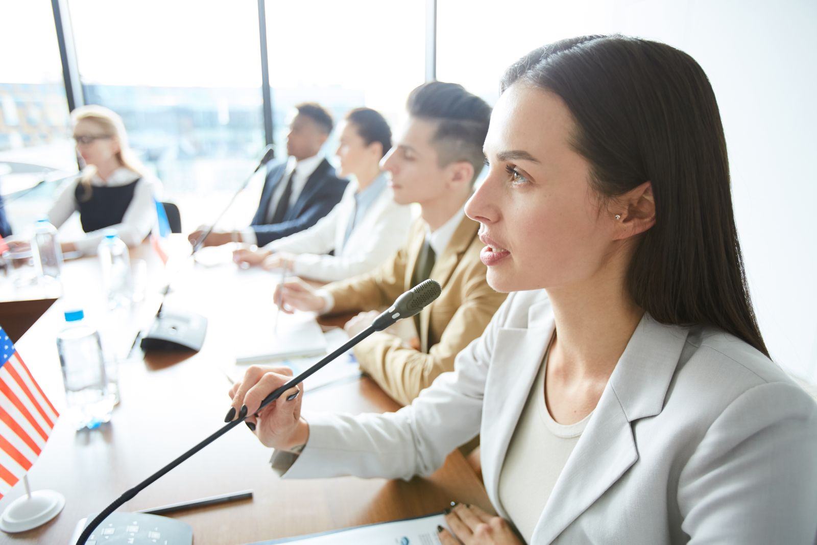 Serious confident female politician speaking into microphone